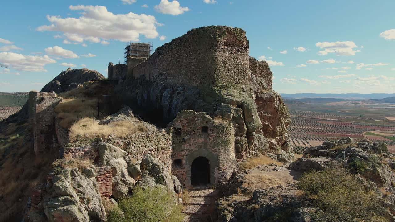 Vista aerea ravvicinata in salita con drone dell'entrata del Castello di Peña Negra a Mora, Toledo, che rivela le sue piccole dimensioni pedonali, non progettato per carri, e i dettagli in pietra della fortezza medievale