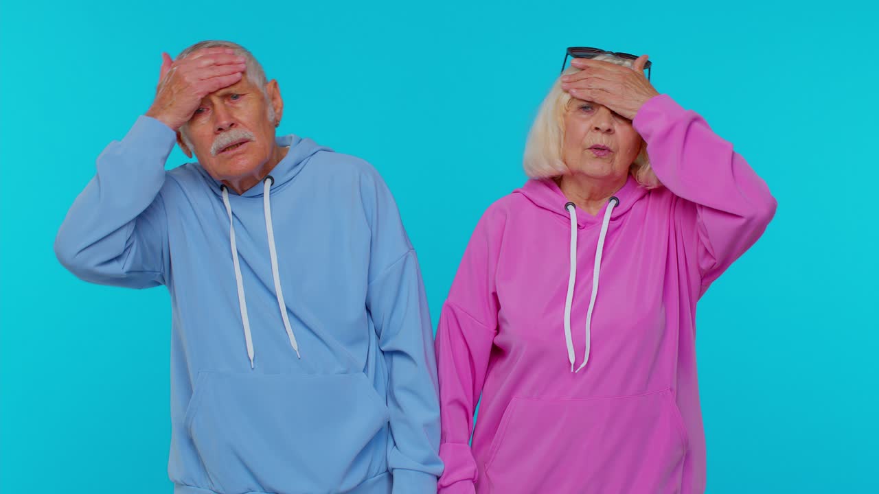 Upset senior grandparents making face palm gesture, feeling bored, disappointed in result, bad news