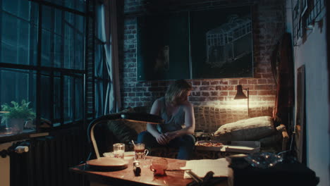 man sitting on a couch in a room at night