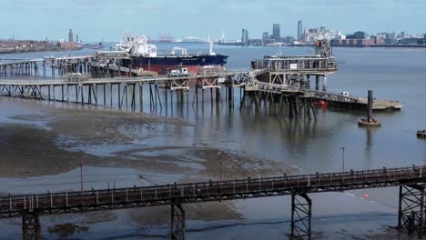 crude oil tanker ship loading at refinery harbour terminal pier aerial view dolly right