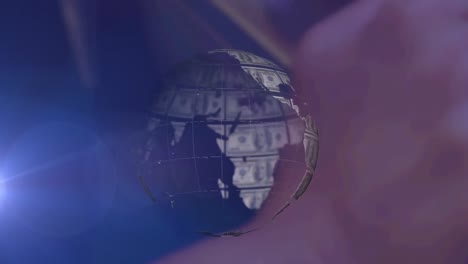 animation of rotating globe of dollar bills, over dark background with pink blur and white light