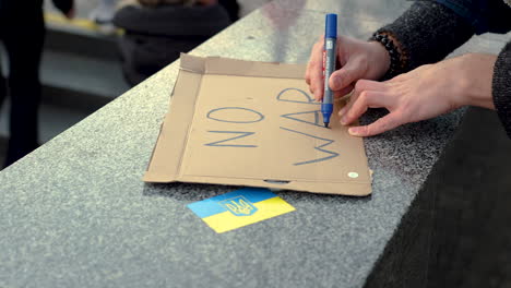 de escribir un cartel de protesta contra la guerra en ucrania en una manifestación, de cerca