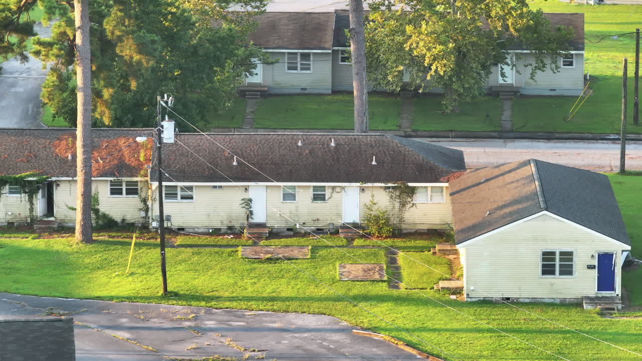 Cinematic drone shot of abandoned apartments with vegetation growing on the buildings, panning aerial footage