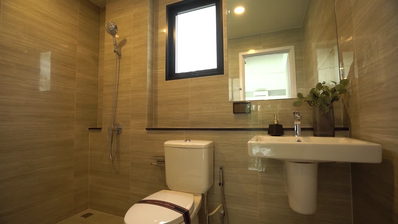 y limpio baño de baldosas de pared de color beige, a través del paseo