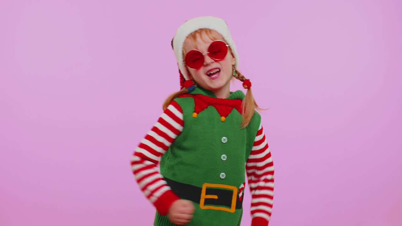 Dívka, vánoční skřítek Santa Clause, poslouchá hudbu přes sluchátka, tančí disko, blbne a baví se