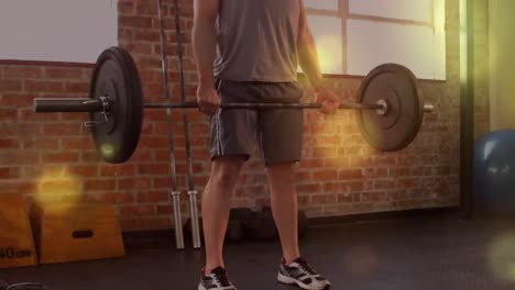 animation of glowing spots over strong man exercising in gym