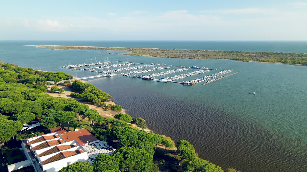 vista aérea del puerto deportivo de el rompido y yates amarrados en el muelle del río piedras, ojos de pájaro del océano atlántico, deslizándose a la derecha