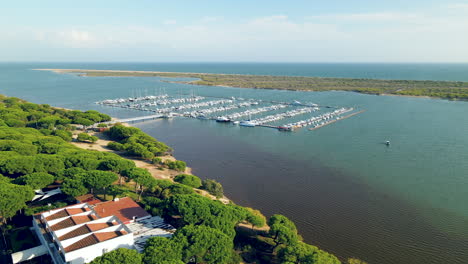 aerial view of el rompido marina and yatchs moored at the dock on piedras river, atlantic ocean bird's eyes, sliding right