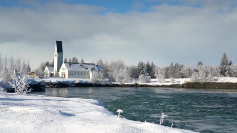 selffos church on snowy winter landscape near olfusa river in iceland. panning shot