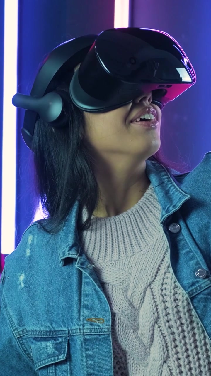 Giovane Donna Immersa nella Realtà Virtuale in uno Studio Illuminato al Neon