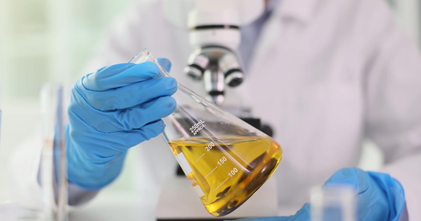 Laboratory technician in gloves analyzes yellow substance