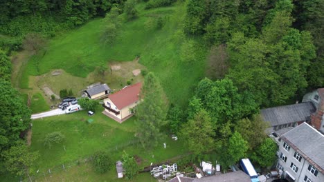 Family-house-in-middle-of-green-nature-beside-small-industrial-building-with-big-chimney