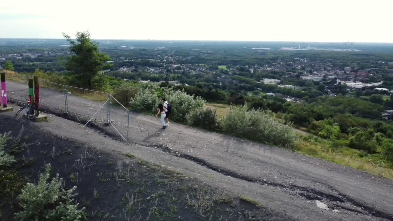 Couple running on a hill with a view