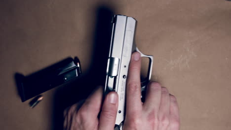 hands unloading 9mm pistol making weapon safe