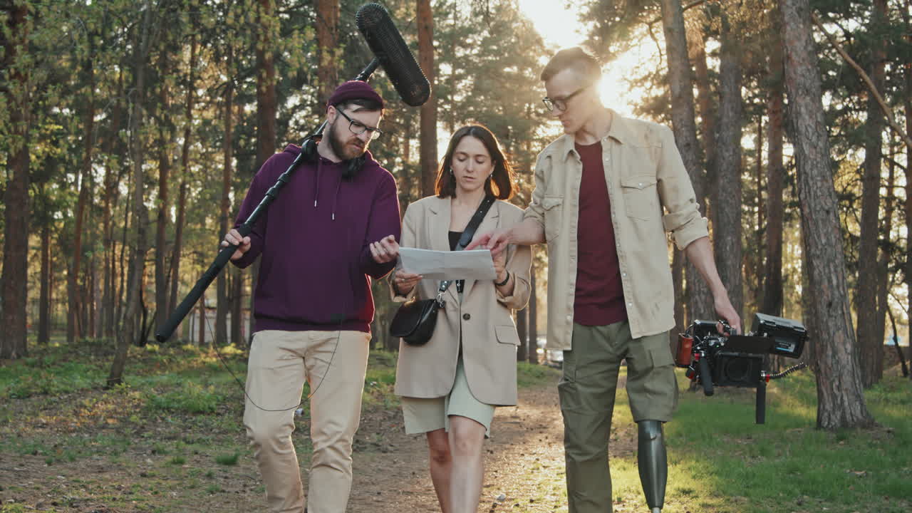 Filming Crew With Video Camera Walking Along Forest