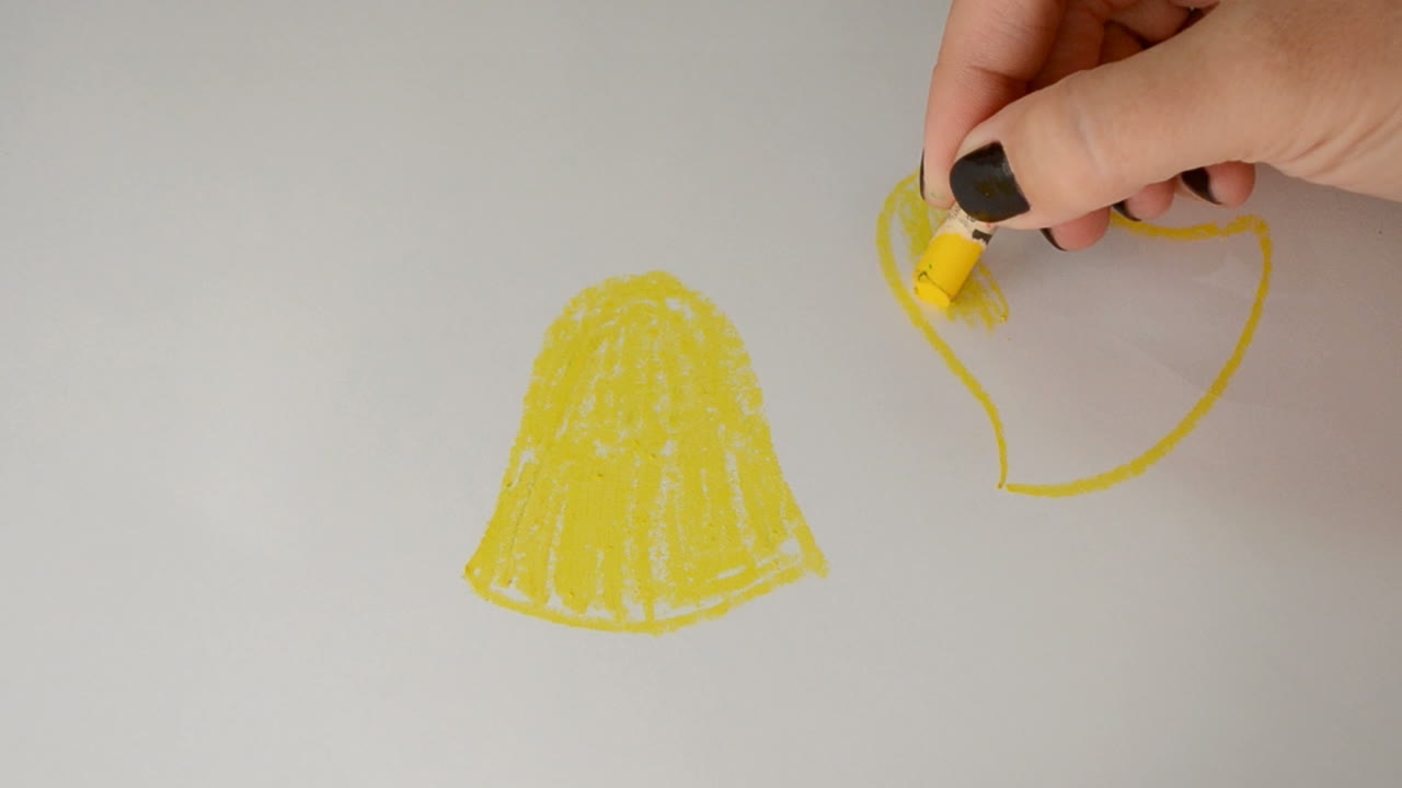 The woman draws a pastel festive hand bells. Drawing process