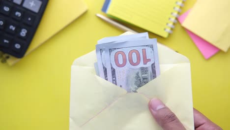 money in envelope on a yellow desk