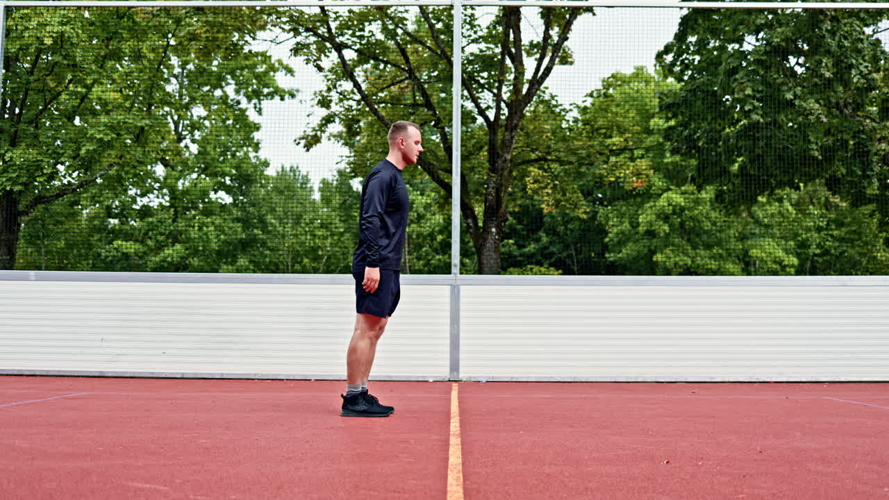 Muž v kraťasech a tričku cvičí na sportovišti na čerstvém vzduchu. Muž sportuje sám venku. Zdravý životní styl. Ranní trénink v parku.