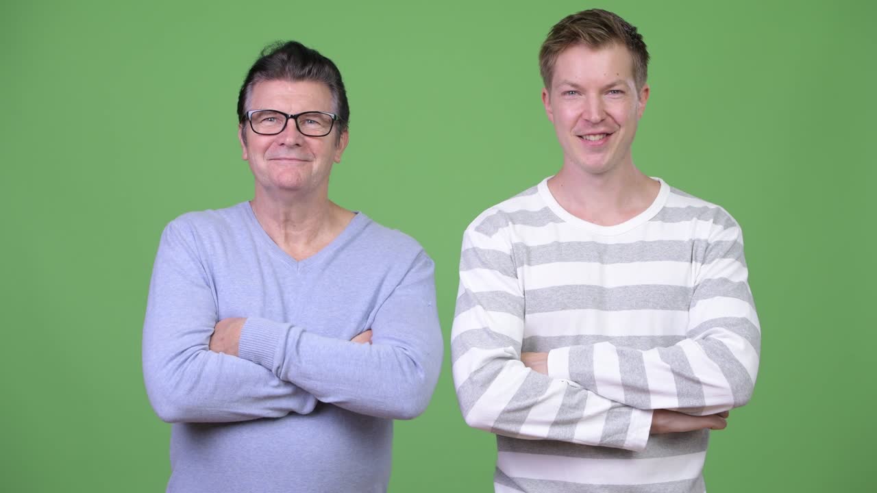 Senior handsome man and young handsome man with arms crossed together