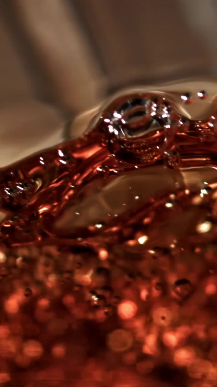 Primo piano di liquido ambrato scintillante con bollicine che salgono