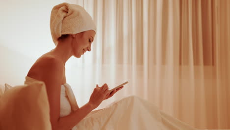 woman using phone in bed