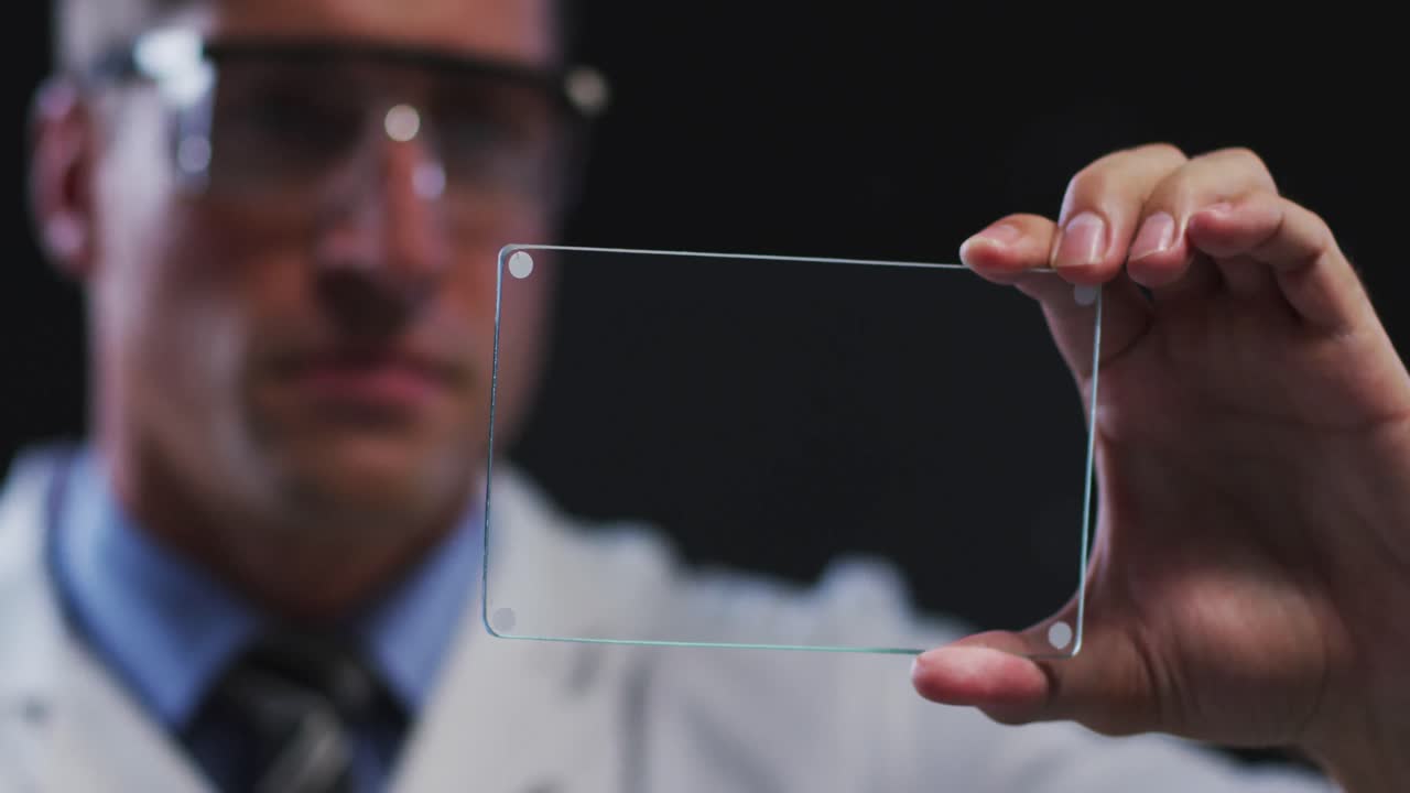 Caucasian male doctor using handheld interface touch screen