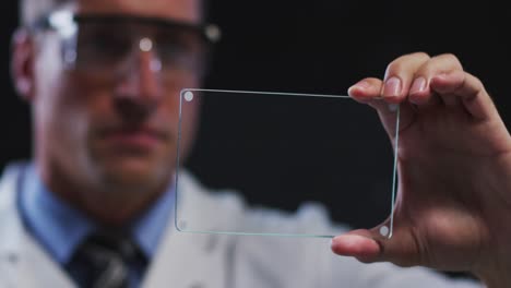 médico masculino caucásico usando una pantalla táctil de interfaz de mano