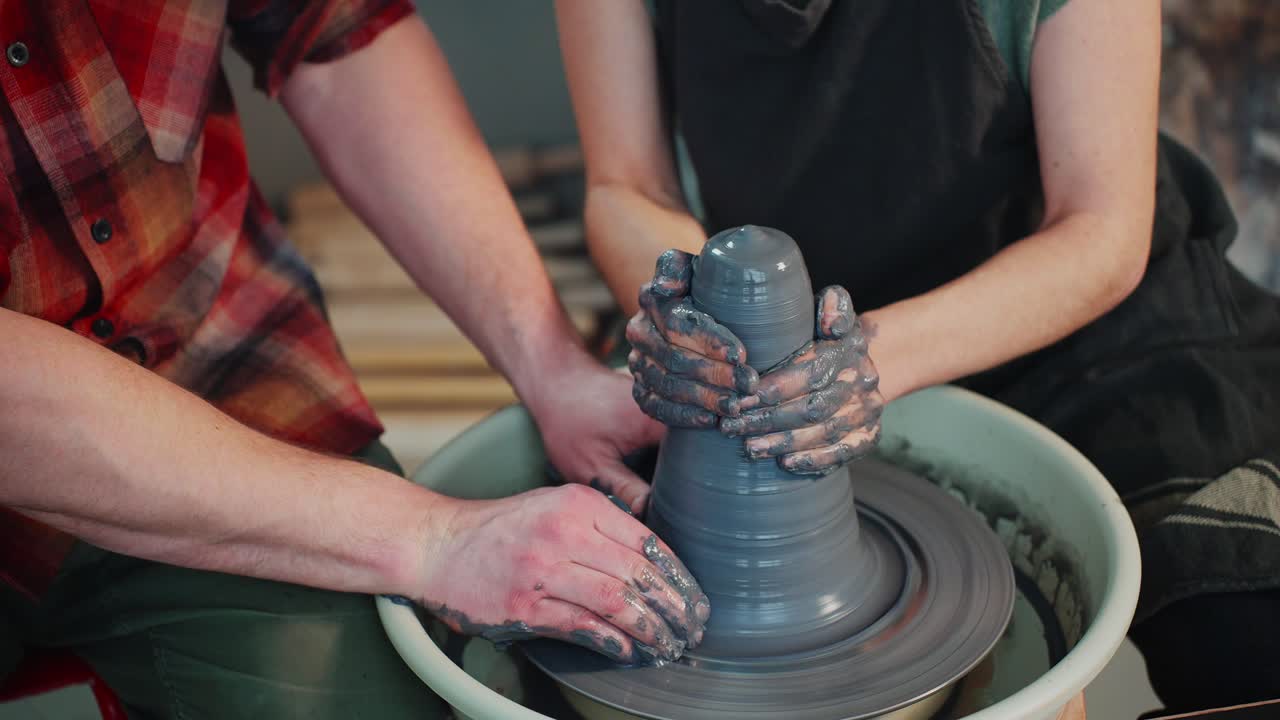 Couple learning pottery on a pottery wheel