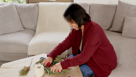 creating festive wreath, senior woman enjoying christmas crafts at home