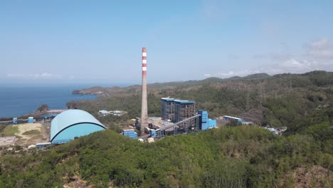 aerial view of the steam power plant located in pacitan district, between the hills and the southern coast of java island