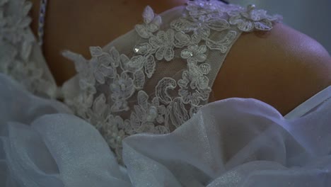 close-up of a wedding dress shoulder with lace and embellishments