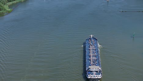 industrial barge voyage: drone panning down river view from wekendam to antwerpen