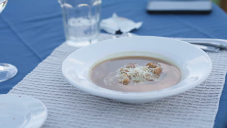 Pan-right-over-soup-chowder-in-white-and-blue-setting,-close-up