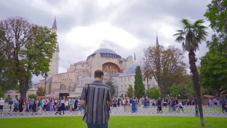 traveling in istanbul, the young man takes a selfie on the phone and is happy.