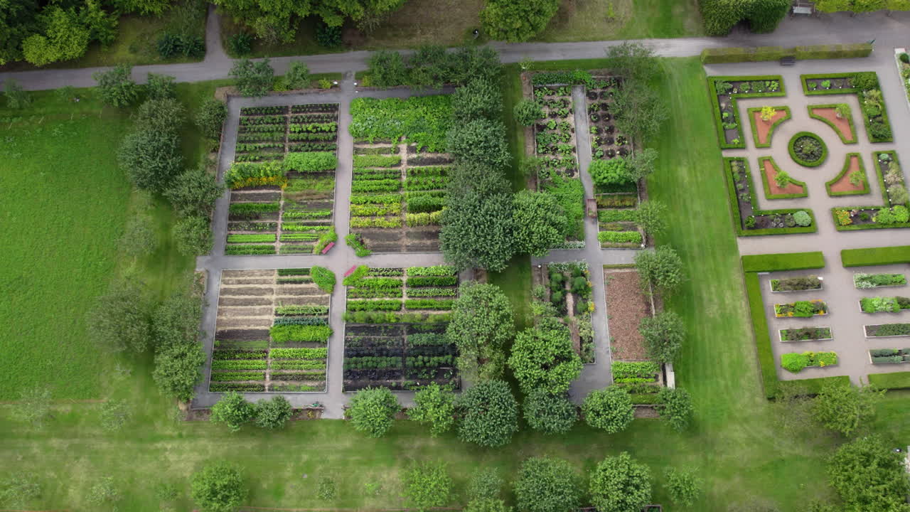 Fredriksdal Museum and Gardens, Helsingborg, Sweden - Neatly Arranged Garden Plots Sit in a Wide Green Space Surrounded by Trees - Aerial Drone Shot