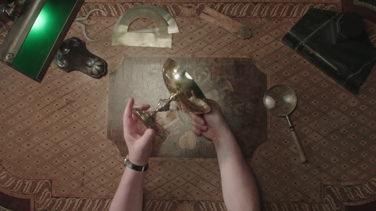 An older man evaluates an old silver item