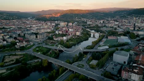 aerial drone shot of ourense city in galicia, spain, capturing the city's layout and natural landscape at sunset