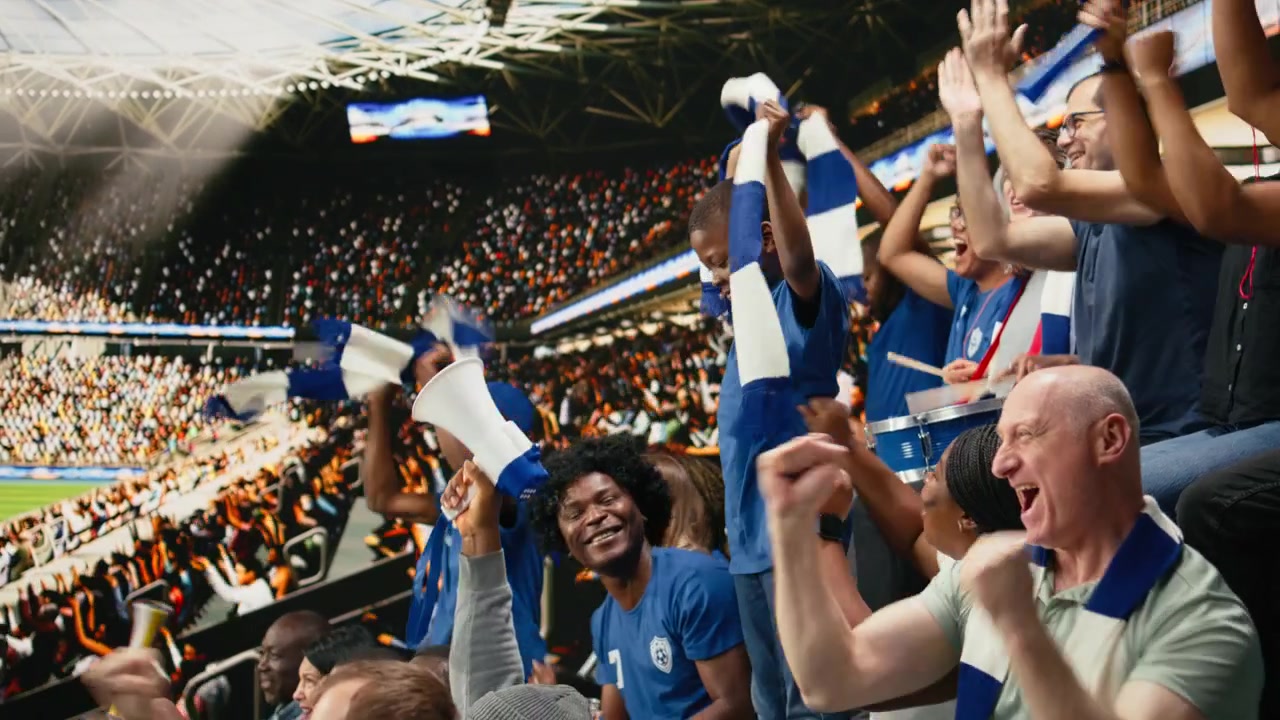 Joven aficionado infantil celebra con hinchas de fútbol azules animando en el estadio.