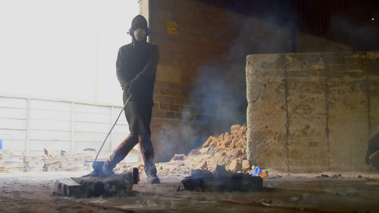 trabajador masculino tirando de metal moldeado en caliente en el taller 4k