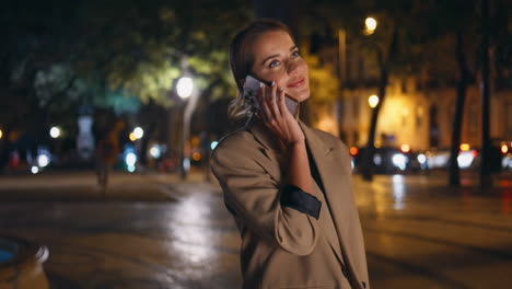 una mujer de moda contestando llamadas en la calle nocturna. una mujer de negocios relajada hablando.