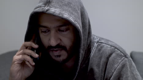 close up shot of an indian man talking to an anonymous caller, discussing the availability and negotiating the details of an underground business deal