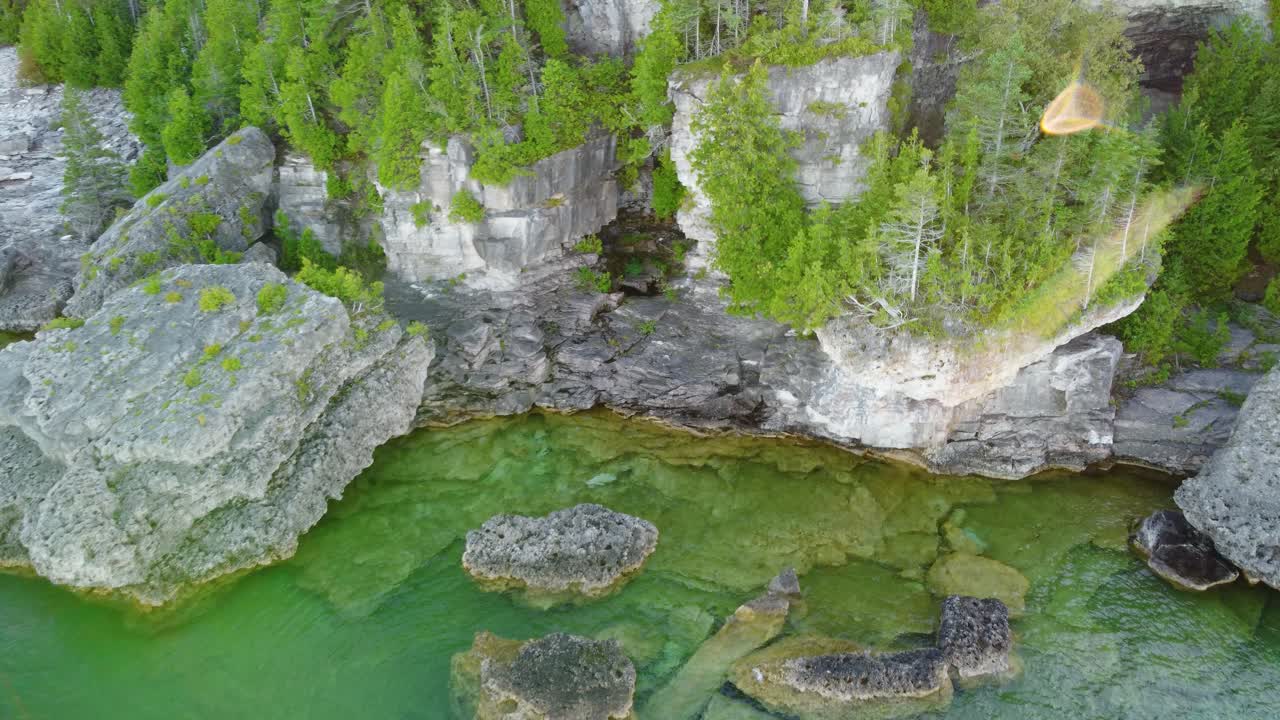 Flygfoto som visar stränderna vid Lake Huron med oländig klippterräng och tallskogar.