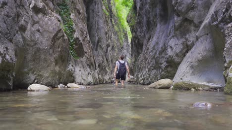 young man walking on the creek in the canyon.