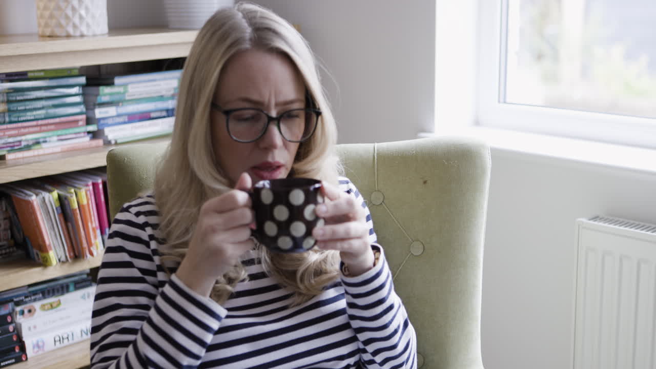 Woman drinking from a mug indoors