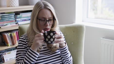 woman drinking from a mug indoors