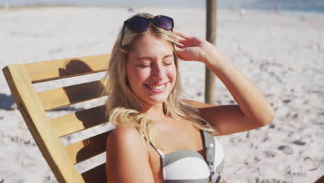 Caucasian-woman-sitting-on-a-sunbed-on-the-beach