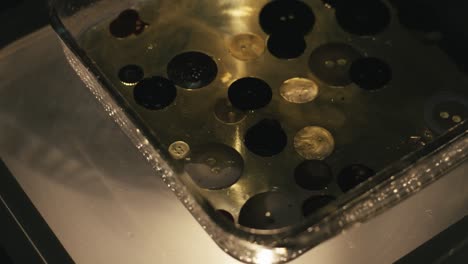 cleaning buttons and small objects in a water-filled container