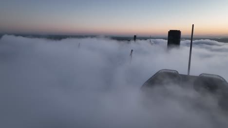 Aerial-shot-above-a-cloudy-foggy-Brisbane-City,-with-only-the-tops-of-sky-scrapers-being-visible