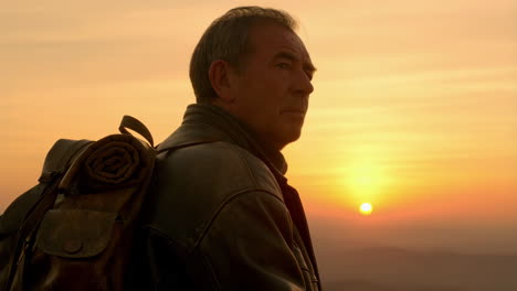 man with backpack at sunset