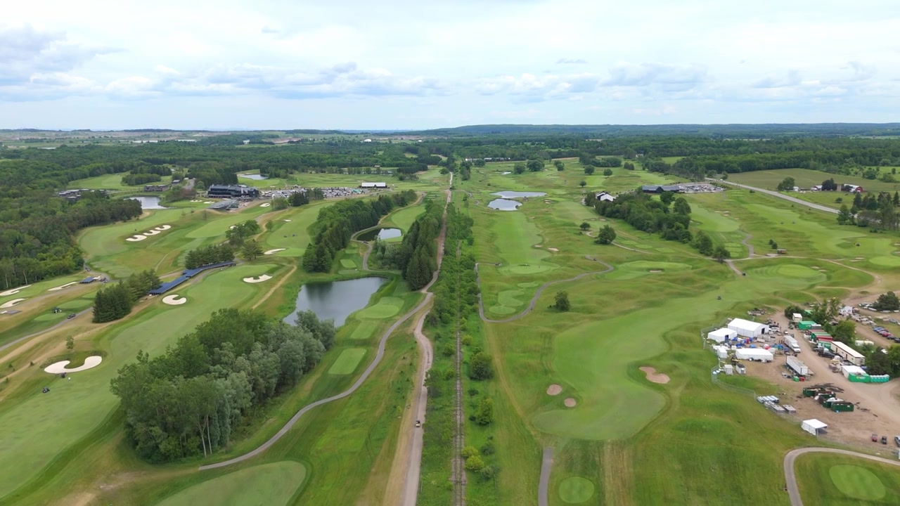 Atemberaubendes Drohnenvideo, das den TPC Toronto Osprey Valley Golfplatz mit üppigen Fairways, Wasserhindernissen und gepflegten Grüns bei hellem Tageslicht zeigt, aufgenommen in flüssigen, filmischen Luftaufnahmen.